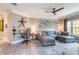 Bright living room featuring comfortable gray sectional, a modern ceiling fan, and unique fish-themed wall art at 4323 Bayside Village Dr # 229, Tampa, FL 33615