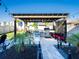 Outdoor kitchen area features a built-in grill, pergola and accent lighting to enhance evening entertainment at 5571 Birch River Trl, Wesley Chapel, FL 33545