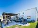 This backyard offers a covered outdoor kitchen, lounge area, and lush landscaping at 5571 Birch River Trl, Wesley Chapel, FL 33545