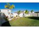 Backyard features a white vinyl fence, lush green grass, and well-maintained landscaping at 5571 Birch River Trl, Wesley Chapel, FL 33545