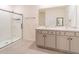 Elegant bathroom boasts double sinks, marble counters, and a glass-enclosed shower for a spa-like experience at 5571 Birch River Trl, Wesley Chapel, FL 33545