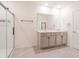 Bright bathroom features double vanities, modern fixtures and a seamless glass enclosed shower at 5571 Birch River Trl, Wesley Chapel, FL 33545