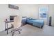 Bedroom with a desk, dresser, comfortable bed, and a bright window with natural light at 5571 Birch River Trl, Wesley Chapel, FL 33545