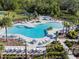 Expansive community pool area featuring multiple pools, lounge chairs, lush landscaping, and resort-style amenities at 5571 Birch River Trl, Wesley Chapel, FL 33545