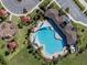 Overhead shot of the resort-style pool area with lounge chairs, palm trees, shade structures, and playground at 5571 Birch River Trl, Wesley Chapel, FL 33545