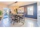 Dining room with a wooden table and six chairs underneath a stylish modern lighting fixture at 5571 Birch River Trl, Wesley Chapel, FL 33545