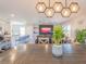 A dining room features modern lighting and view of the living room and kitchen breakfast bar at 5571 Birch River Trl, Wesley Chapel, FL 33545