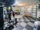 Clean and organized garage with gym equipment, tool storage, and a checkered floor, offering practical space at 5571 Birch River Trl, Wesley Chapel, FL 33545