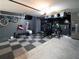 Spacious garage featuring a home gym setup, checkered floor, and ample storage solutions for fitness enthusiasts at 5571 Birch River Trl, Wesley Chapel, FL 33545