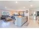 Open concept living room, dining room and kitchen island with stainless steel appliances at 5571 Birch River Trl, Wesley Chapel, FL 33545