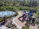A colorful community playground featuring various play structures, seating, and safety surfacing surrounded by mature trees at 5571 Birch River Trl, Wesley Chapel, FL 33545
