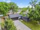 Aerial view showcasing the home's landscaped yard, driveway, and dark gray roof at 5907 Tampa Shores Blvd, Tampa, FL 33615