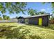 Backyard view with concrete patio, sliding glass doors, and large grassy area at 5907 Tampa Shores Blvd, Tampa, FL 33615