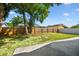 Fenced backyard features green grass, mature trees, and a concrete patio at 5907 Tampa Shores Blvd, Tampa, FL 33615