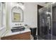 Modern bathroom featuring sleek black toilet, stylish vanity, black shower with glass door and gold fixtures at 5907 Tampa Shores Blvd, Tampa, FL 33615