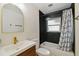 Updated bathroom featuring modern vanity, black tiled shower/tub and a sleek black shower curtain at 5907 Tampa Shores Blvd, Tampa, FL 33615