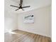 Bright bedroom featuring wood-look floors, a modern ceiling fan, and a view of the landscape through the window at 5907 Tampa Shores Blvd, Tampa, FL 33615