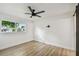 Minimalist bedroom with a ceiling fan, light wood floors, and a view of the outdoors at 5907 Tampa Shores Blvd, Tampa, FL 33615