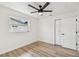 Bedroom with wood-look flooring, modern fan, closet with white doors, and a well-lit window at 5907 Tampa Shores Blvd, Tampa, FL 33615