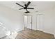 Spacious bedroom featuring wood-look floors, modern fan, and ample closet space at 5907 Tampa Shores Blvd, Tampa, FL 33615