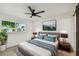Cozy bedroom with a large bed, modern furnishings, and a view of the outside greenery at 5907 Tampa Shores Blvd, Tampa, FL 33615