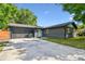 Charming single story home with a well-manicured lawn, dark brick, garage and a concrete driveway at 5907 Tampa Shores Blvd, Tampa, FL 33615