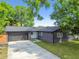 Charming home exterior with a dark gray brick facade, dark trim, and a spacious driveway at 5907 Tampa Shores Blvd, Tampa, FL 33615