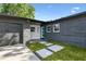 Modern single-story home featuring a colorful front door and a well-maintained lawn at 5907 Tampa Shores Blvd, Tampa, FL 33615