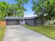 This home features fresh landscaping, large driveway and a dark gray exterior at 5907 Tampa Shores Blvd, Tampa, FL 33615