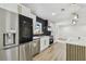 Renovated kitchen with stainless appliances, a black backsplash, and island with quartz countertop at 5907 Tampa Shores Blvd, Tampa, FL 33615
