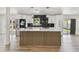 Open kitchen featuring stainless steel appliances, bright white cabinets, and contemporary lighting fixtures at 5907 Tampa Shores Blvd, Tampa, FL 33615
