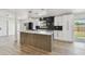 Open kitchen featuring stainless steel appliances, bright white cabinets and contemporary lighting fixtures at 5907 Tampa Shores Blvd, Tampa, FL 33615