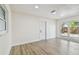 Bright living room with light wood flooring, neutral walls, and sliding glass doors leading to the backyard at 5907 Tampa Shores Blvd, Tampa, FL 33615