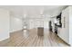 Bright open-concept living area with light wood floors, a modern kitchen, and white walls at 5907 Tampa Shores Blvd, Tampa, FL 33615