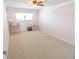 Bedroom featuring a ceiling fan, large windows, and neutral carpet and trim at 5925 Shore S Blvd # 608, Gulfport, FL 33707