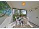 Screened balcony with a round table and chairs, perfect for outdoor relaxation with garden view at 6123 113Th St # 510, Seminole, FL 33772