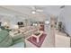 Inviting living room with mirrored wall, ceiling fan, and a partial view into the kitchen and dining area at 6123 113Th St # 510, Seminole, FL 33772