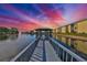 Scenic waterfront pier with a gazebo offers tranquil views of the water and building at sunset at 6123 113Th St # 510, Seminole, FL 33772