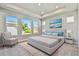 Spacious primary bedroom with tray ceiling, windows, and decorative beach art above bed at 671 Allora Ave, Nokomis, FL 34275