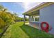 Exterior showing green grass, covered patio, view of backyard, and black metal fence at 6907 Crestpoint Dr, Apollo Beach, FL 33572