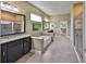 Elegant bathroom showcasing a soaking tub, walk-in shower, and dual vanities with granite countertops at 6907 Crestpoint Dr, Apollo Beach, FL 33572