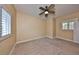 Empty bedroom features tan paint, neutral carpet, ceiling fan, and bright white trim and shutters at 6907 Crestpoint Dr, Apollo Beach, FL 33572
