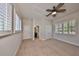 Bedroom showcasing two windows, carpet, closet, ceiling fan, and ensuite bathroom at 6907 Crestpoint Dr, Apollo Beach, FL 33572