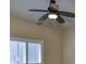 Bedroom ceiling fan with wood blades and light fixture, and plantation shutters on the windows at 6907 Crestpoint Dr, Apollo Beach, FL 33572