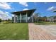 Striking community clubhouse with modern architecture, manicured lawn, and paved pathway for outdoor enjoyment at 6907 Crestpoint Dr, Apollo Beach, FL 33572