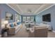 Bright living room featuring a coffered ceiling, neutral furniture, and large windows with plantation shutters at 6907 Crestpoint Dr, Apollo Beach, FL 33572
