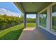 Exterior displaying covered patio with open view to green grass, palms, and black metal fence at 6907 Crestpoint Dr, Apollo Beach, FL 33572