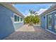 View of brick patio showcasing lush landscaping, plants, and access to the home at 6907 Crestpoint Dr, Apollo Beach, FL 33572