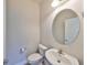 Powder room featuring a toilet, a sink and an oval mirror at 6907 Crestpoint Dr, Apollo Beach, FL 33572