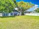 Well-kept backyard with a charming blue home and storage shed, enclosed by a crisp white fence at 714 W Peninsular St, Tampa, FL 33603